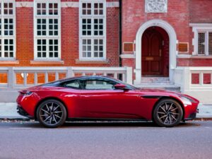 coupé rouge garé devant un bâtiment en briques brunes