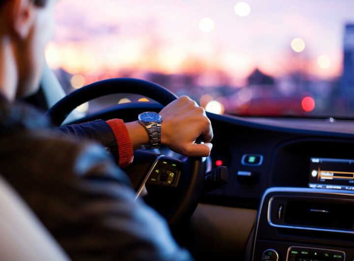 man driving a car wearing wrist watch