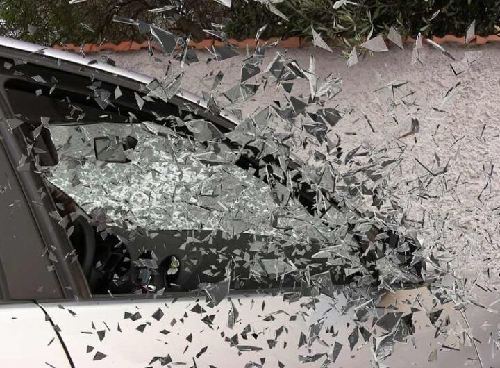 Vitre de voiture explosée, éclats de verre en vol, mur en arrière-plan