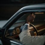 Un homme dans une voiture ajuste le rétroviseur avec sa main