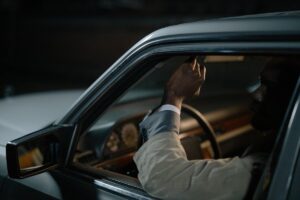 Un homme dans une voiture ajuste le rétroviseur avec sa main