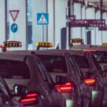 Des taxis alignés devant un bâtiment avec panneaux routiers