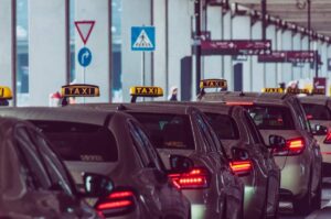 Des taxis alignés devant un bâtiment avec panneaux routiers