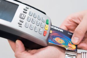 Une main insère une carte bancaire dans un terminal de paiement