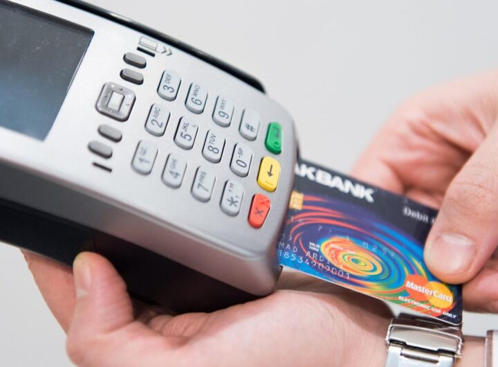 Une main insère une carte bancaire dans un terminal de paiement